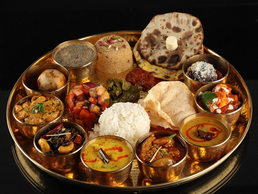 Big tray serving a collection of Indian dishes